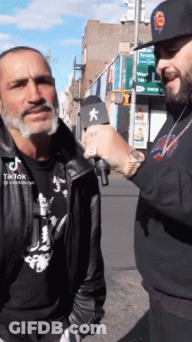 Man In Black Jacket Being Interviewed GIF