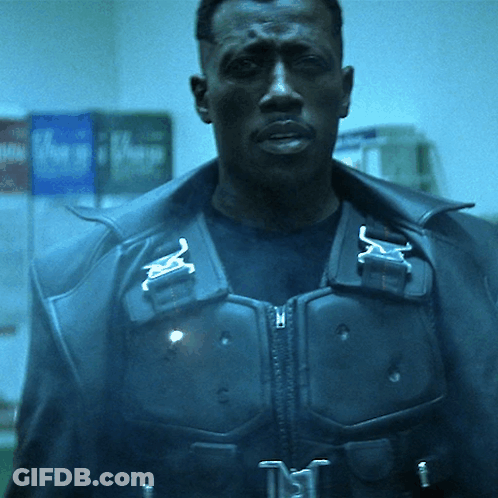A Man Wearing A Black Jacket With A Buckle That Says ' N ' On It GIF