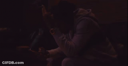 A Man Wearing A Black Jacket With The Word Rap On It Looks At His Cell Phone GIF
