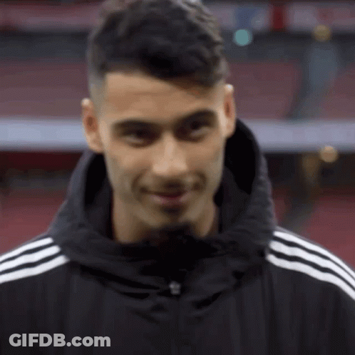 A Man Wearing A Black Jacket With White Stripes On The Sleeves GIF