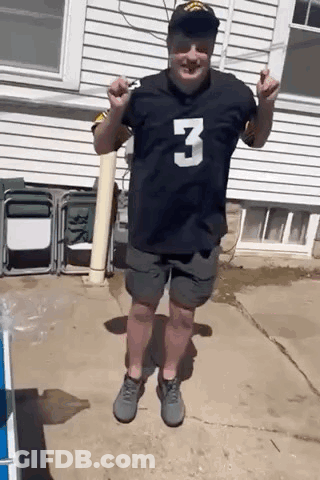 A Man Wearing A Black Jersey With The Number 3 On It Is Standing In Front Of A White House . GIF