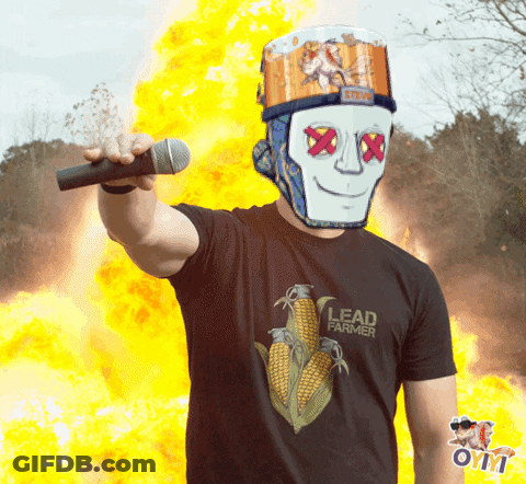 A Man Wearing A Black Lead Farmer Shirt Holds A Microphone GIF