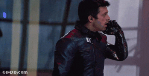 A Man Wearing A Black Leather Jacket And A Black Glove Is Talking On A Cell Phone GIF