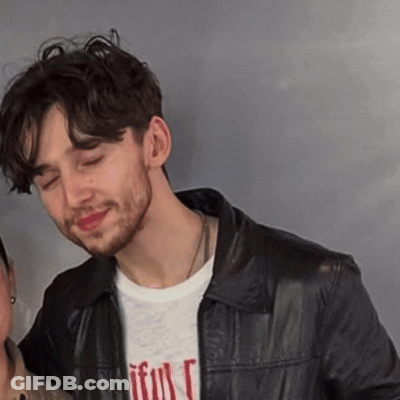 A Man Wearing A Black Leather Jacket And A T-Shirt That Says " Faithful " GIF