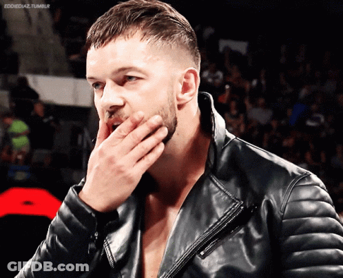 A Man Wearing A Black Leather Jacket Covers His Mouth With His Hand GIF