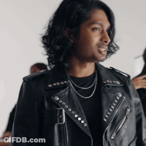 A Man Wearing A Black Leather Jacket With Studs On The Sleeves GIF