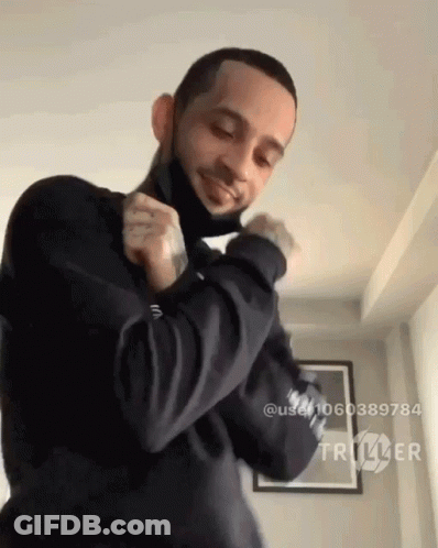 A Man Wearing A Black Mask Is Dancing In A Room With Triller Written On The Bottom Right GIF