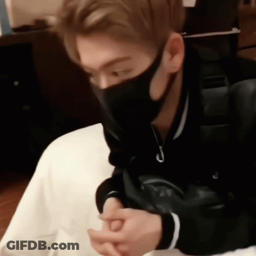 A Man Wearing A Black Mask Is Sitting On A Chair . GIF