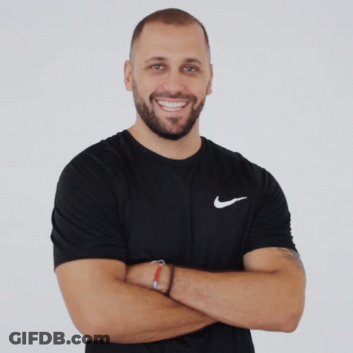 A Man Wearing A Black Nike Shirt With His Arms Crossed Smiles For The Camera GIF