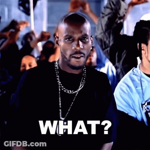 A Man Wearing A Black Shirt And A Chain Says What GIF