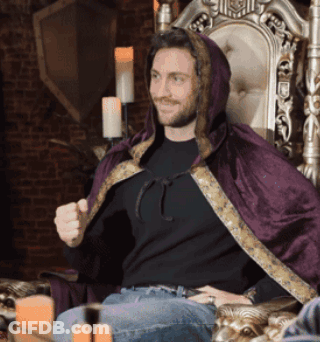 Man In Black Shirt And Purple Cape Sitting In Chair GIF