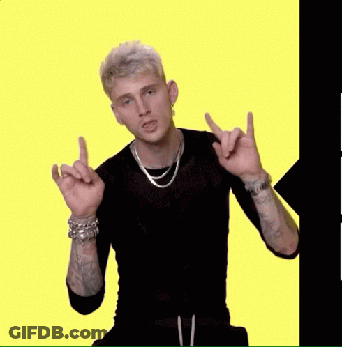 A Man Wearing A Black Shirt And A Silver Necklace Is Pointing At Something GIF