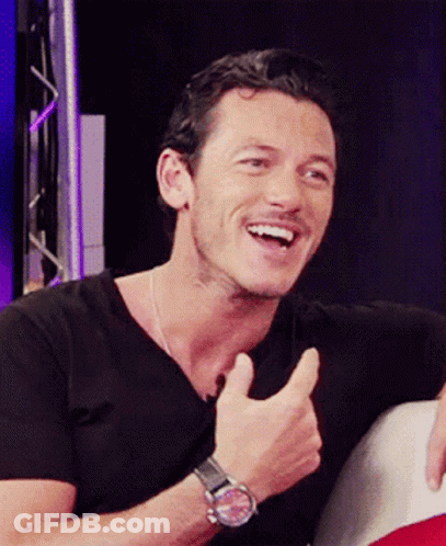 A Man Wearing A Black Shirt And A Watch Giving A Thumbs Up GIF