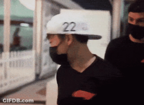 A Man Wearing A Black Shirt And A White Hat With The Number 22 On It GIF
