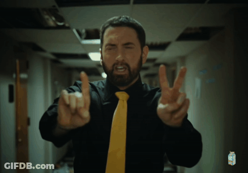 A Man Wearing A Black Shirt And A Yellow Tie Has A Carton Of Minute Maid On His Shirt GIF