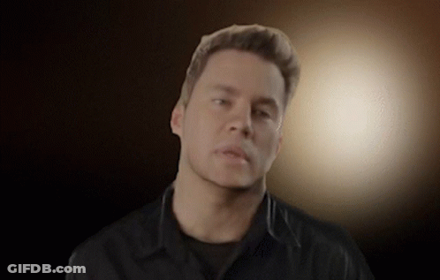 A Man Wearing A Black Shirt Looks At The Camera GIF