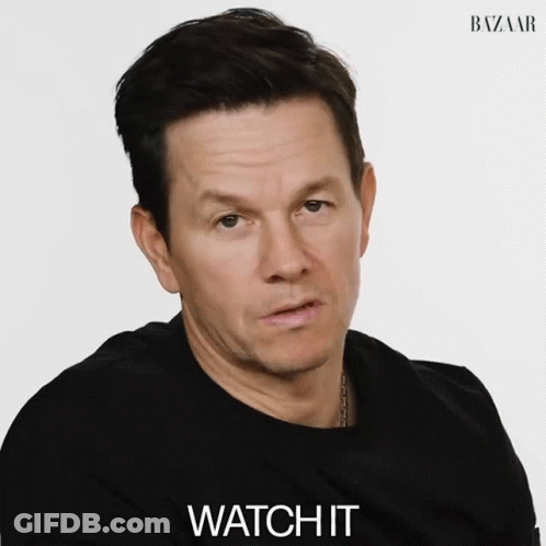 A Man Wearing A Black Shirt Says Watch It In Front Of A White Background GIF