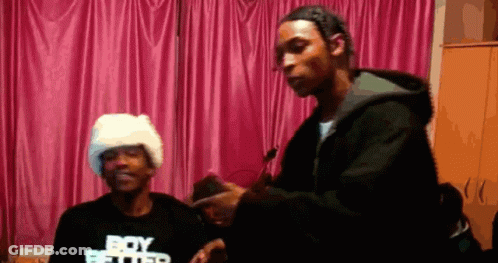 A Man Wearing A Black Shirt That Says Boy Better Is Standing Next To Another Man GIF