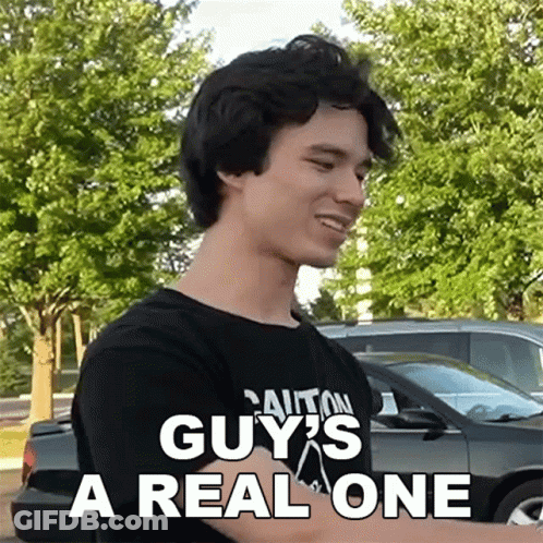 A Man Wearing A Black Shirt That Says Caution Guy 'S A Real One On It GIF