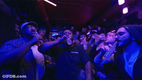 A Man Wearing A Black Shirt That Says It 'S Cool Stands In Front Of A Crowd GIF