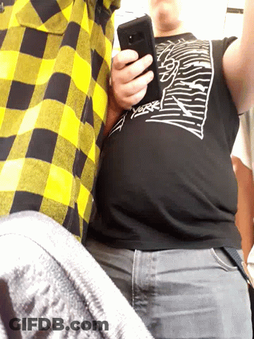 A Man Wearing A Black Shirt That Says ' Thrasher ' On It Holds A Cell Phone GIF