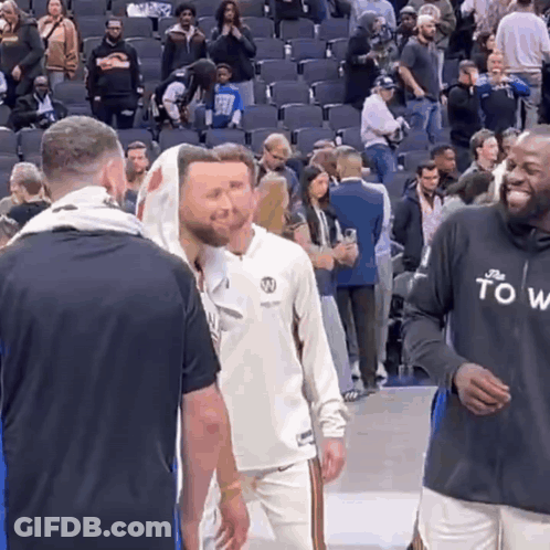 A Man Wearing A Black Shirt That Says " To Win " Talks To Another Man GIF