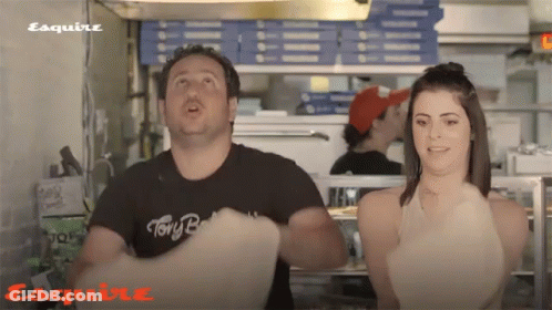 A Man Wearing A Black Shirt That Says " Tony B " Is Standing Next To A Woman GIF