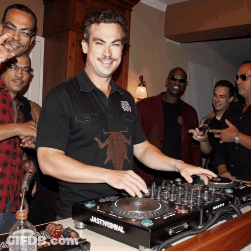 A Man Wearing A Black Shirt With A Cockroach On It Is Playing Music On A Jasthennial Dj Mixer GIF