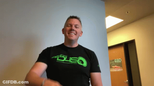A Man Wearing A Black Shirt With A Green Logo That Says Dsq GIF