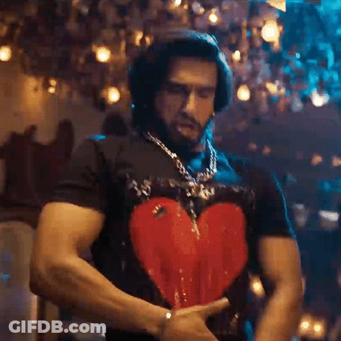 A Man Wearing A Black Shirt With A Heart On It GIF