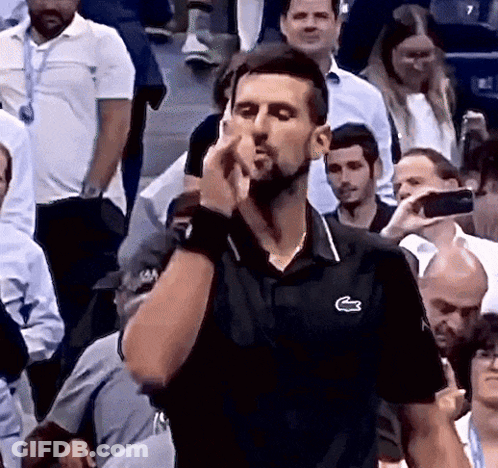 A Man Wearing A Black Shirt With A Lacoste Logo On The Front GIF