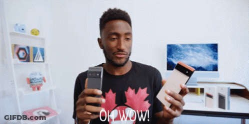 A Man Wearing A Black Shirt With A Maple Leaf On It Is Holding A Cell Phone And A Tablet And Says Oh Wow GIF