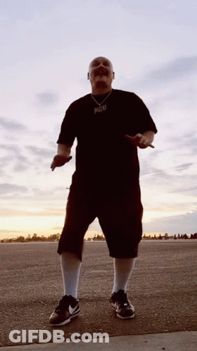 A Man Wearing A Black Shirt With A Pendant That Says ' Reggae ' On It GIF
