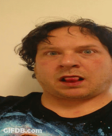 A Man Wearing A Black Shirt With A Picture Of A Shark On It Is Making A Funny Face GIF