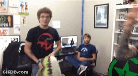 A Man Wearing A Black Shirt With A Skull On It Is Standing In A Room With Two Other Men GIF