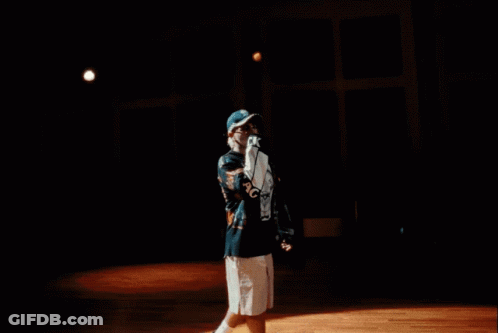 A Man Wearing A Black Shirt With A Skull On It Is Standing In Front Of A Light GIF