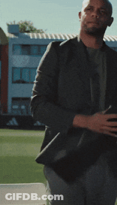 A Man Wearing A Black Shirt With A White T On It GIF