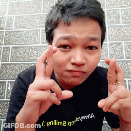 A Man Wearing A Black Shirt With A Yellow Smiley Face On It GIF