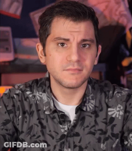 A Man Wearing A Black Shirt With A Zelda Logo On It GIF