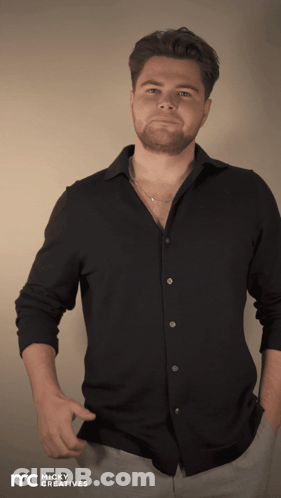 A Man Wearing A Black Shirt With Micky Creatives Written On The Bottom Right GIF