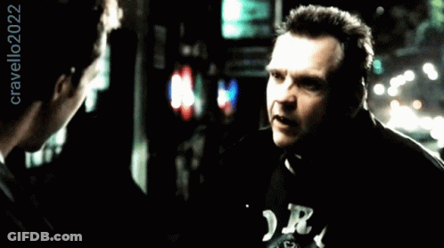A Man Wearing A Black Shirt With The Letter R On It Talks To Another Man GIF