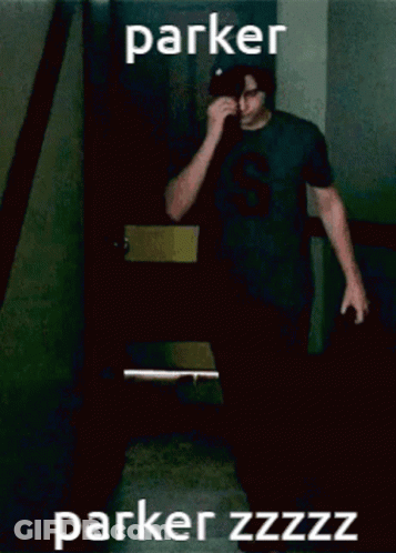 A Man Wearing A Black Shirt With The Letter S On It Wipes His Nose GIF