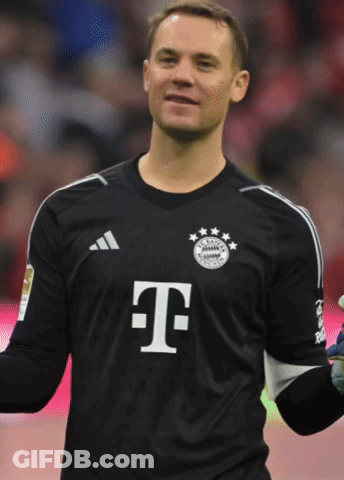 A Man Wearing A Black Shirt With The Letter T On The Front GIF