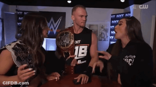 A Man Wearing A Black Shirt With The Number 18 On It Is Surrounded By Two Women GIF