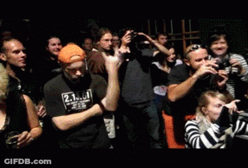A Man Wearing A Black Shirt With The Number 2 On It Stands In A Crowd GIF