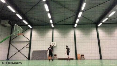 A Man Wearing A Black Shirt With The Number 22 On It Stands In Front Of A Basketball Hoop GIF