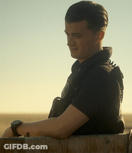 A Man Wearing A Black Shirt With The Word Police On The Back GIF