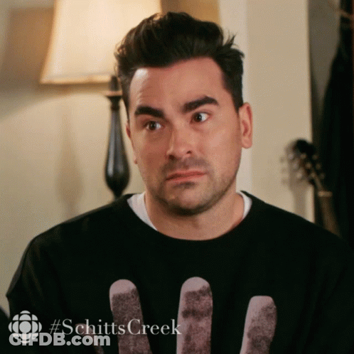 A Man Wearing A Black Shirt With The Word Schitts Creek On The Bottom GIF