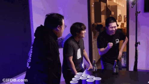 A Man Wearing A Black Shirt With The Word Signal On The Back Is Playing Beer Pong GIF
