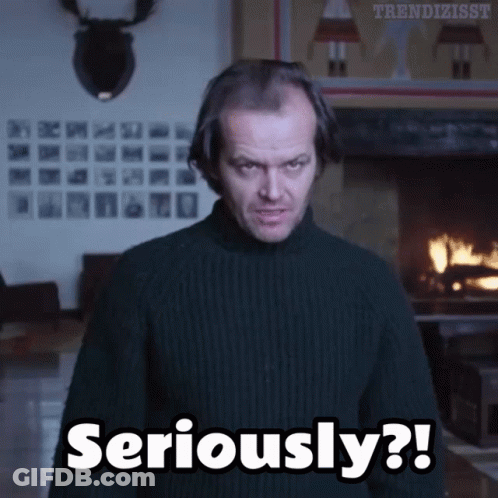 A Man Wearing A Black Sweater Says Seriously In Front Of A Fireplace GIF